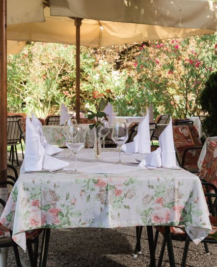 The garden, shaded by majestic chestnut trees, offers an idyllic setting for alfresco dining