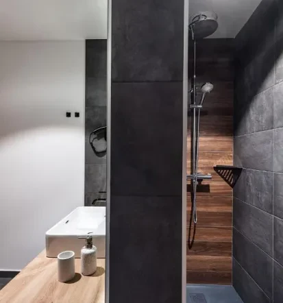 The overview of the apartemnt bathroom, with grey and wooden finish, with shower and sink
