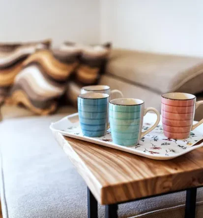 Living room couch for relaxing and a plate with cups for coffee