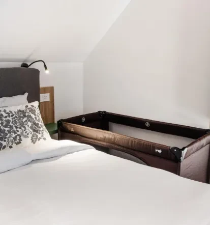 Bedroom with baby cot in Bled apartment